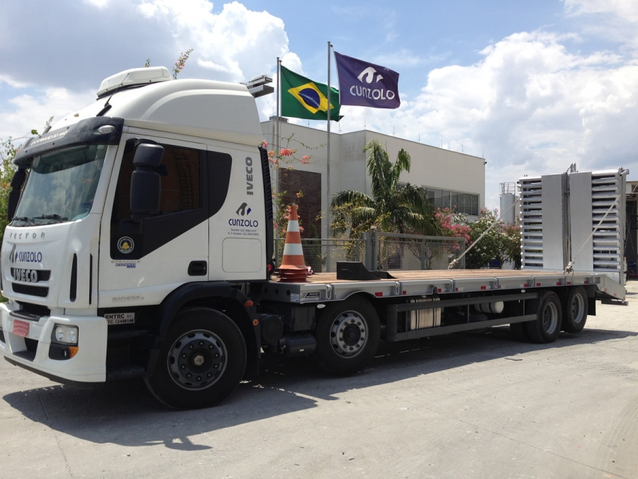 Este caminhão para transporte de cargas pesadas tem uma capacidade útil de 8,90 metros de comprimento e carrega um máximo de 15 toneladas, além de possuir rampa de acesso traseiro em aço com acionamento hidráulico.