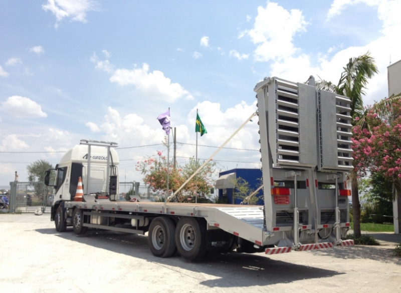 Caminhão Plataforma Carrega Tudo - Transporte Pesado e Remoções Industriais Este caminhão para transporte de cargas pesadas tem uma capacidade útil de 8,90 metros de comprimento e carrega um máximo de 15 toneladas, além de possuir rampa de acesso traseiro em aço com acionamento hidráulico.